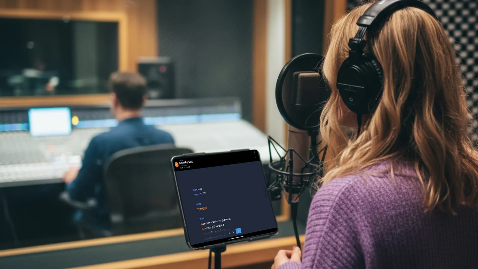 Vocalist using a digital lyrics teleprompter in a recording studio